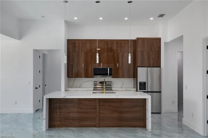 Kitchen with visible vents, open floor plan, modern cabinets, and a sink