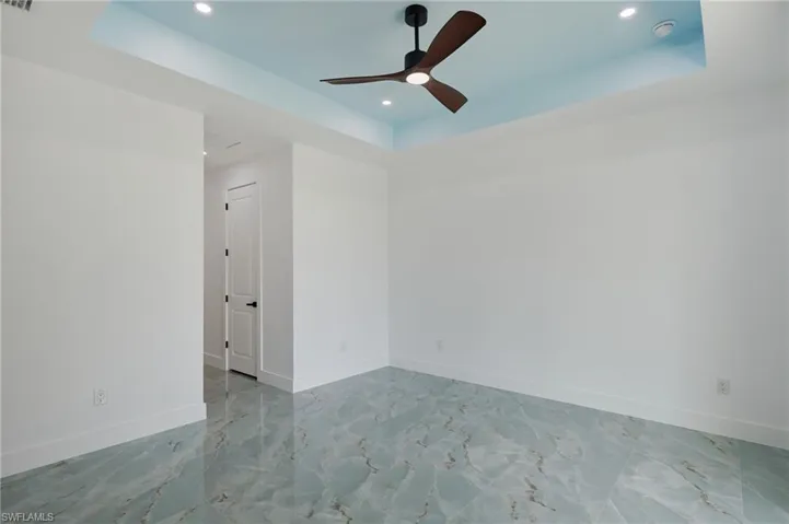 Spare room featuring recessed lighting, ceiling fan, and a tray ceiling