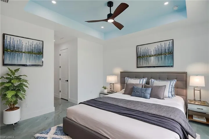 Bedroom with a tray ceiling, baseboards, recessed lighting, a ceiling fan, and marble finish flooring
