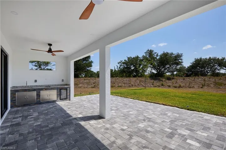 View of patio with a sink, exterior kitchen, ceiling fan, and wine cooler