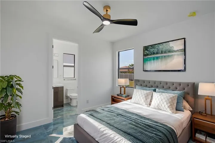Bedroom with baseboards, a ceiling fan, marble finish floor, and ensuite bath