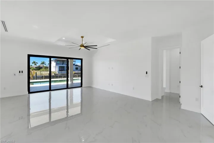 Empty room featuring a ceiling fan and baseboards