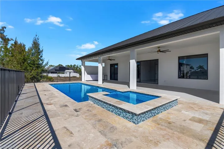 Integrated pool / spa with a patio and a fenced backyard