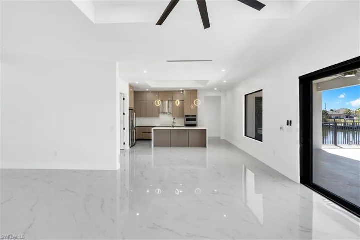 Kitchen with a kitchen island, modern cabinets, light countertops, open floor plan, and light marble finish flooring