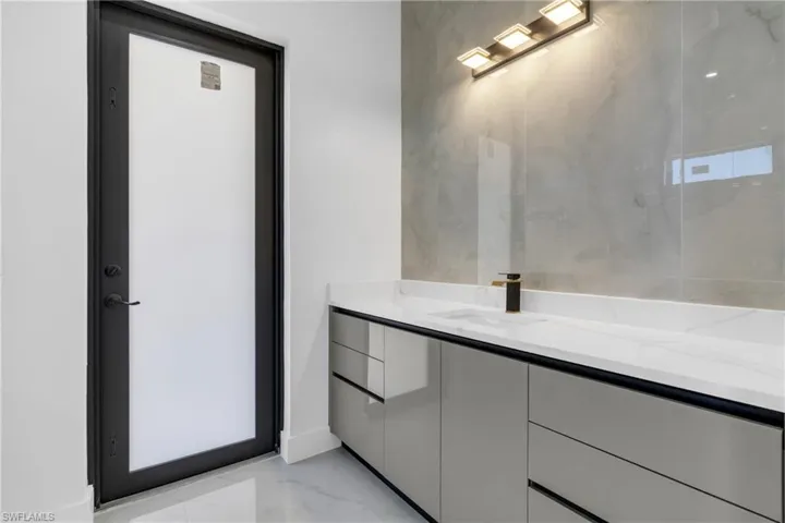 Bathroom with vanity and light marble finish floors