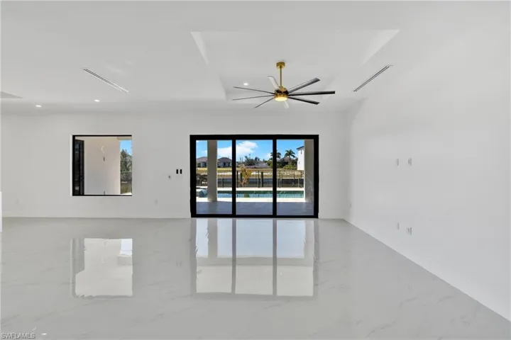 Unfurnished room featuring plenty of natural light, a ceiling fan, light marble finish floors, and recessed lighting