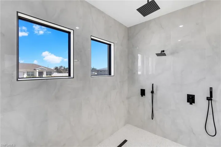 Full bath featuring a marble finish shower