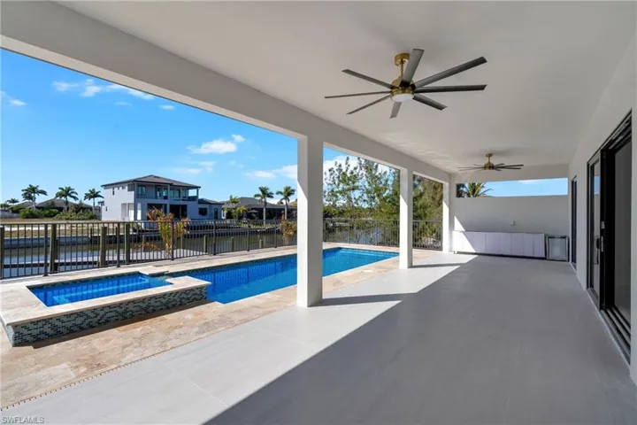 Relaxing pool / spa with a patio area, a fenced backyard, and a water view