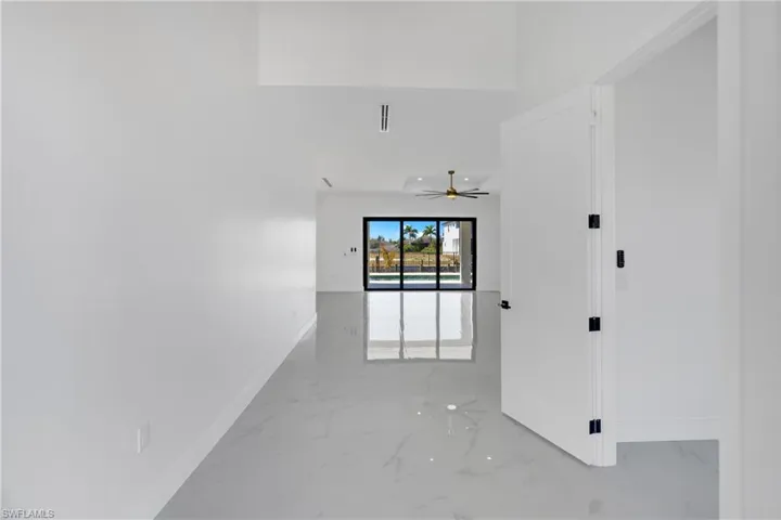 Unfurnished room with light marble finish floors and a ceiling fan