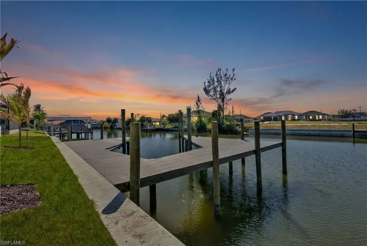 Dock area featuring a water view and a lawn