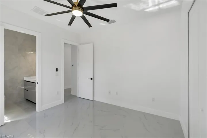 Unfurnished bedroom featuring light marble finish flooring and a ceiling fan