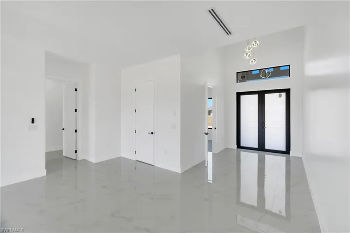 Entryway with french doors and light marble finish floors