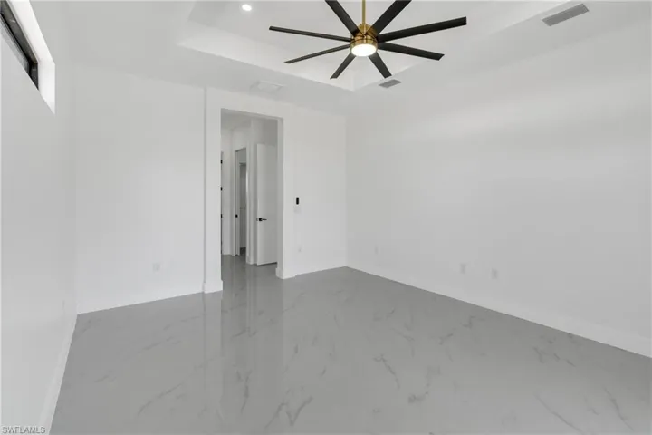 Spare room with a tray ceiling, ceiling fan, and recessed lighting