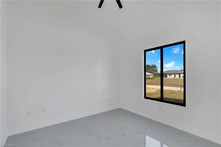 Unfurnished room with light marble finish flooring and a ceiling fan