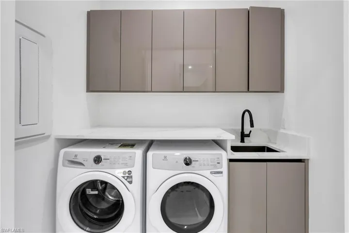 Laundry area with cabinet space and washing machine and clothes dryer