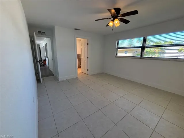 Unfurnished bedroom with light tile patterned floors and ceiling fan
