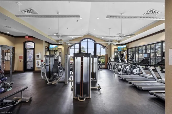 Exercise room featuring ceiling fan, lofted ceiling, and recessed lighting