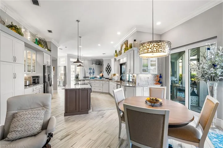 Dining area with plenty of natural light, light hardwood / wood-style flooring, sink, and ornamental molding