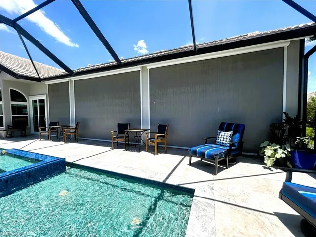 View of swimming pool featuring a patio area and a lanai