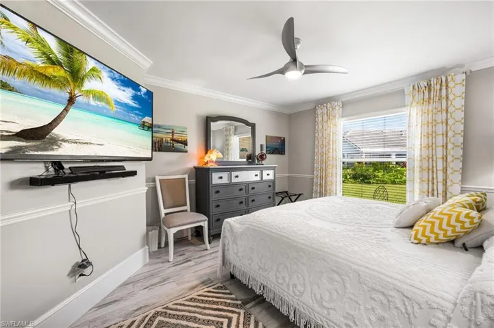 Bedroom with crown molding, ceiling fan, and light hardwood / wood-style floors