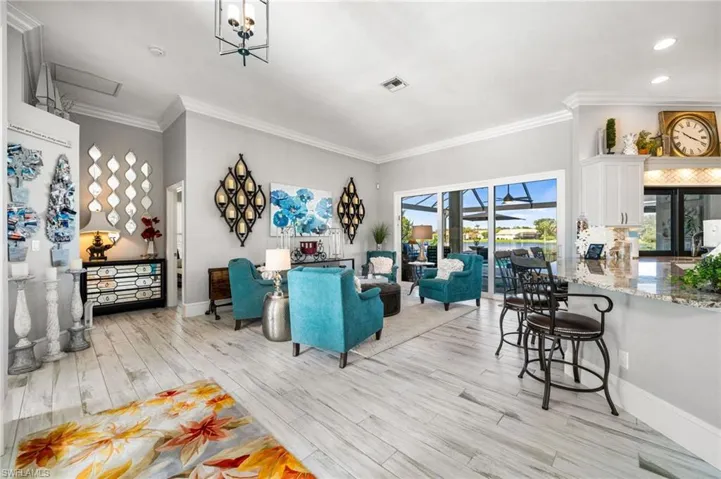 Living room with a notable chandelier, crown molding, and light hardwood / wood-style flooring