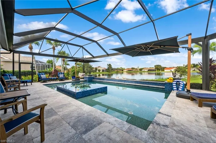 View of pool with a patio, an in ground hot tub, a water view, and glass enclosure