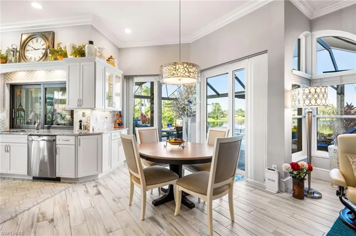 Dining area featuring light wood-type flooring, crown molding, sink, and a high ceiling