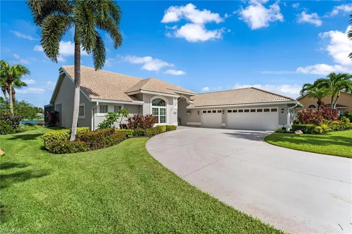 View of front of property with a garage and a front lawn