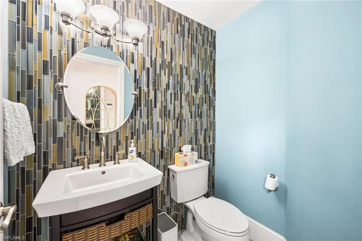 Bathroom with vanity, toilet, and tile walls