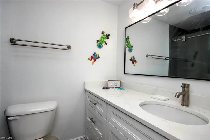 Full bathroom with toilet, a shower, and vanity