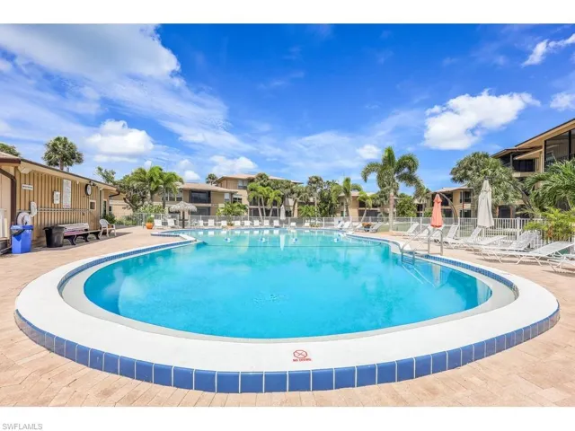 Community pool featuring a residential view, fence, and a patio