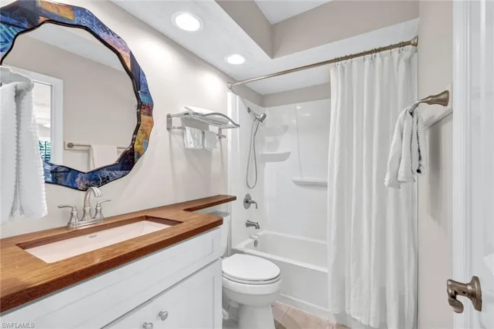 This main en suite bathroom has a very pretty vanity top and features a shower/tub combo.