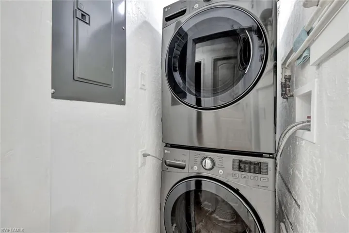 The laundry area is outfitted with a stacked washer and dryer. It also has the updated electric panel and the tankless water heater.