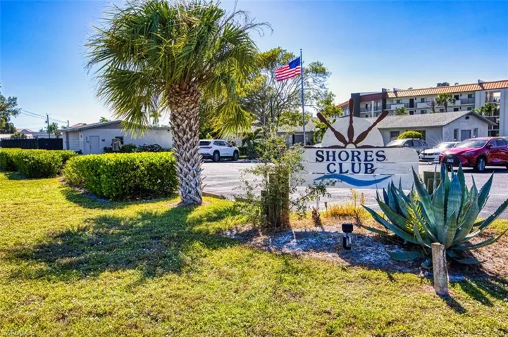 Community / neighborhood sign featuring a lawn
