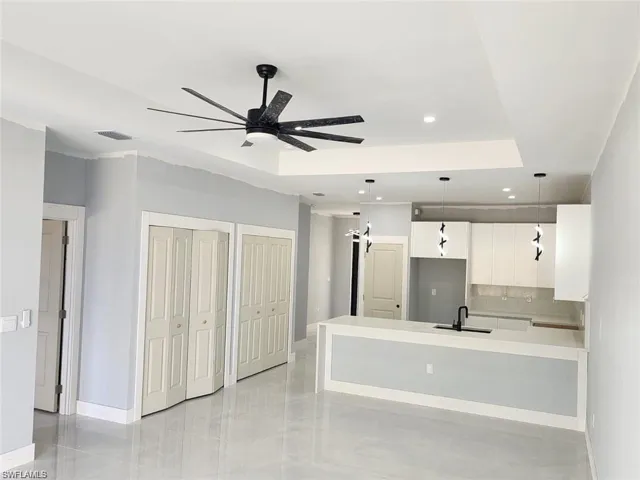 Unfurnished living room with a sink, baseboards, a ceiling fan, and recessed lighting