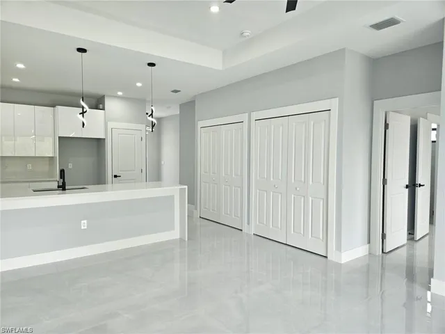 Kitchen with a sink, modern cabinets, white cabinets, recessed lighting, and light countertops