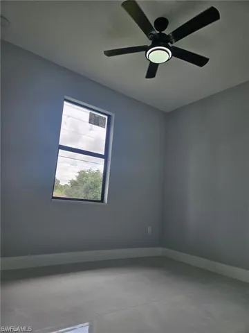 Empty room with baseboards and ceiling fan