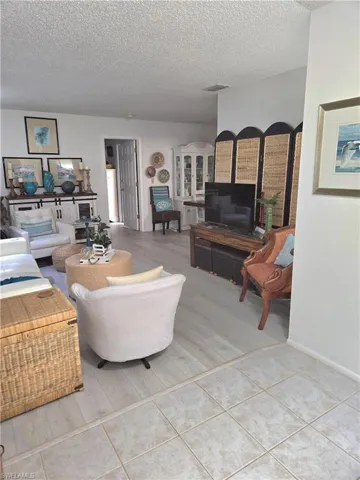Living room featuring tile patterned flooring and a textured ceiling