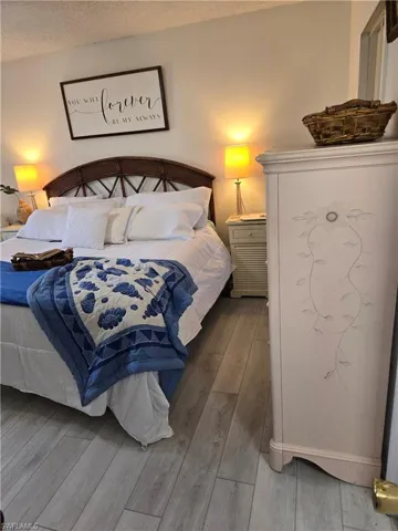Bedroom with hardwood / wood-style floors and a textured ceiling