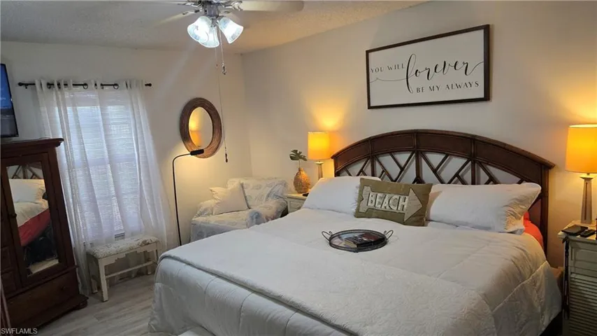Bedroom featuring ceiling fan, wood-type flooring, and a textured ceiling