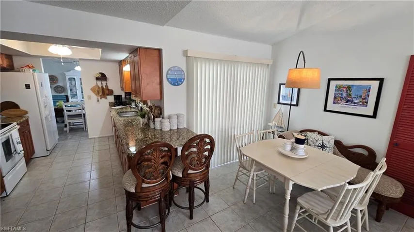 Dining area with sink, light tile patterned floors, and a textured ceiling