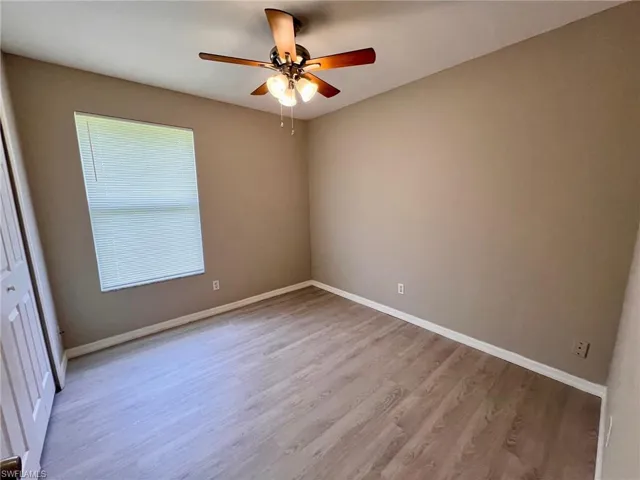 Spare room with light wood finished floors and ceiling fan