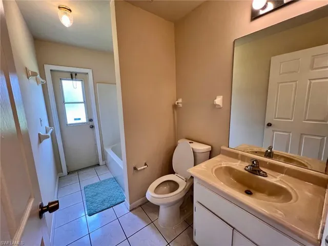 Full bath with light tile patterned floors, vanity, and bathtub / shower combination