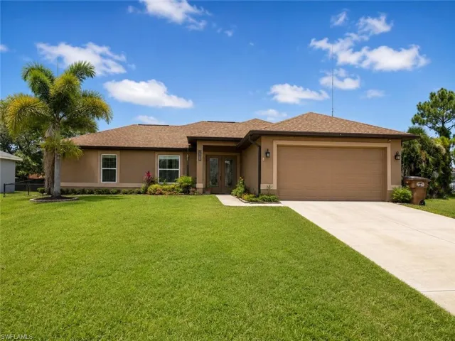 Spacious single-story home featuring a stucco exterior with a gabled roofline and multiple windows