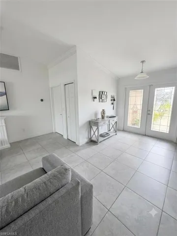 Bright and open foyer featuring tile flooring, recessed lighting, and glass French doors with sidelights providing natural illumination