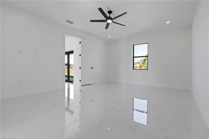 Empty room featuring baseboards, visible vents, a healthy amount of sunlight, and marble finish floor