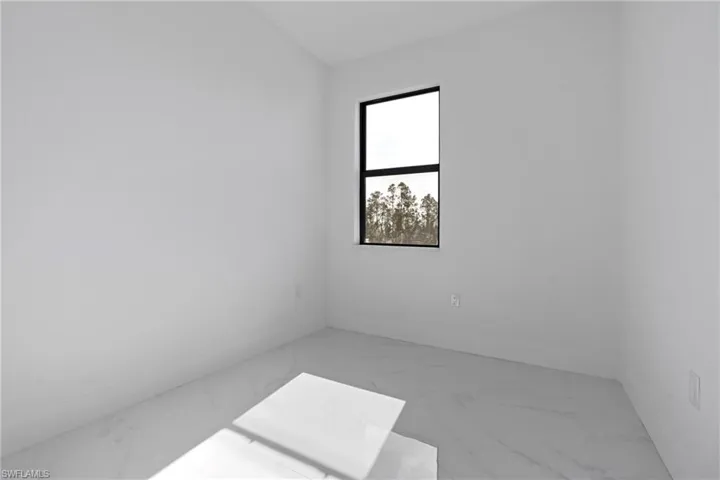 Unfurnished room featuring baseboards and marble finish floor