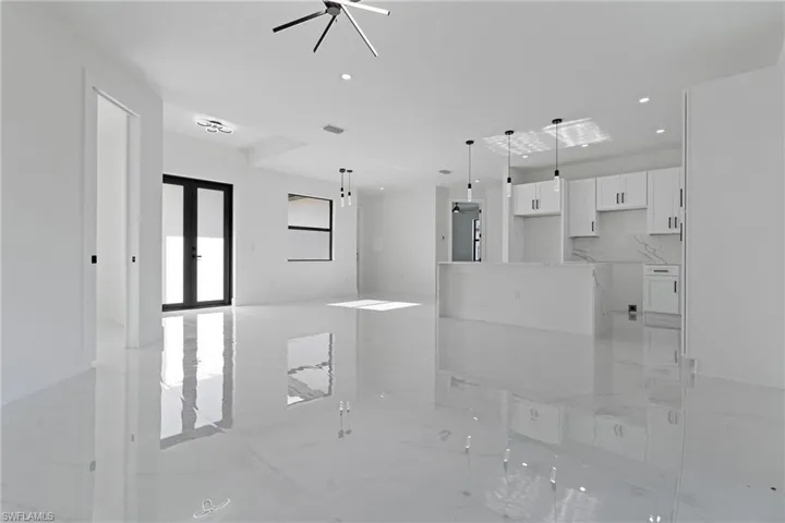 Unfurnished living room with ceiling fan, french doors, marble finish floor, recessed lighting, and baseboards