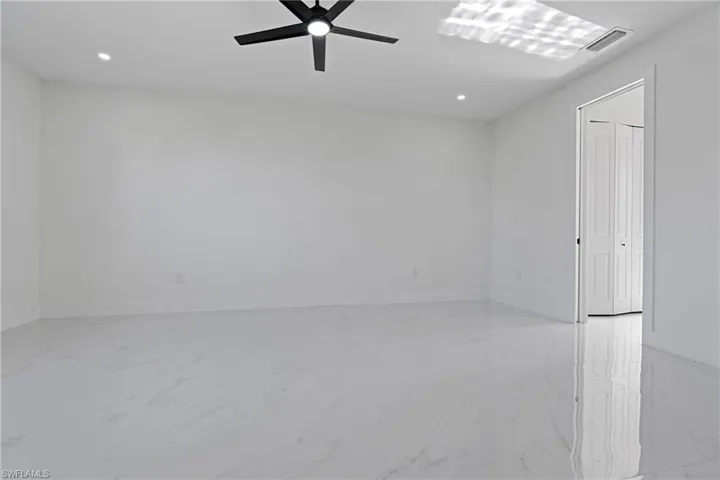 Unfurnished room with ceiling fan, visible vents, baseboards, marble finish floor, and recessed lighting