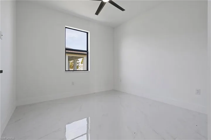 Spare room with baseboards, ceiling fan, and marble finish floor